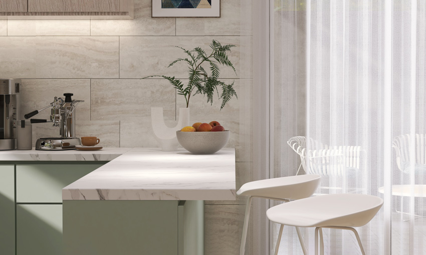 Kitchen space with large wall tiles, marble slab peninsula, backless stools and sage drawers