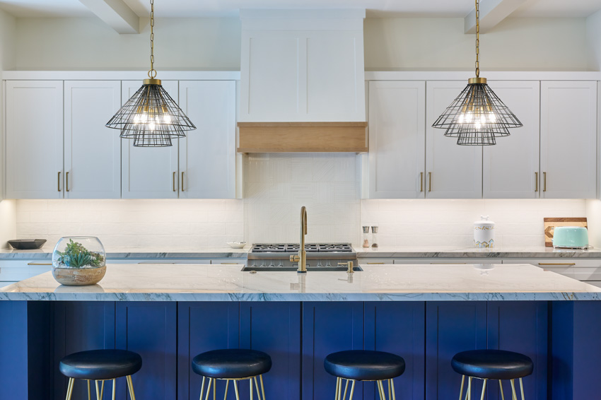 Kitchen with flat panel cabinets, gold finish accessories, under cabinet lighting and blue stools