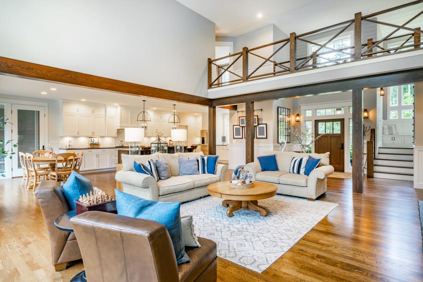 Contemporary living room with loveseat, couch, chairs, rug, coffee table, high ceiling, and wood flooring