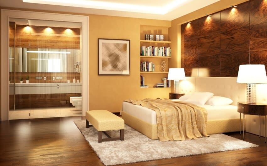 Deep gold modern bedroom with en suite bathroom, recessed book shelf, and hardwood floors