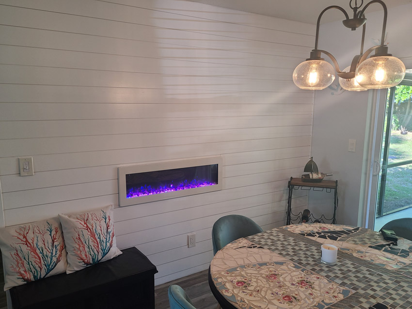 Dining room with shiplap wall, chandelier and round table