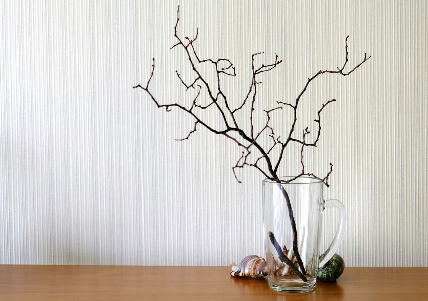 Dry branch of a tree in a glass vase on a wooden table