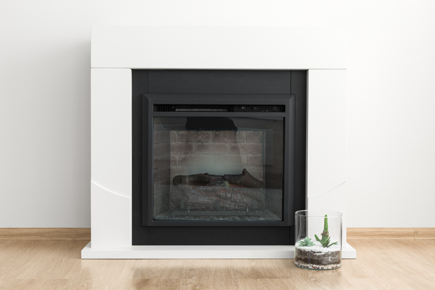 Black finish fireplace inside a white mantel in a room 