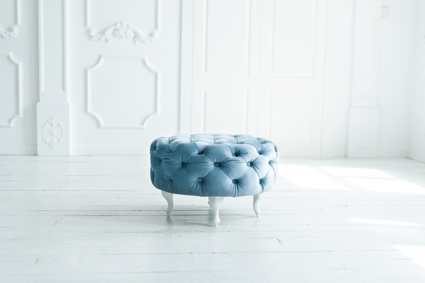 Empty white room with round blue pouf ottoman