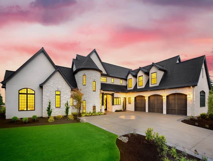 Facade of house with black roof, white brick sidings, and manicured lawn