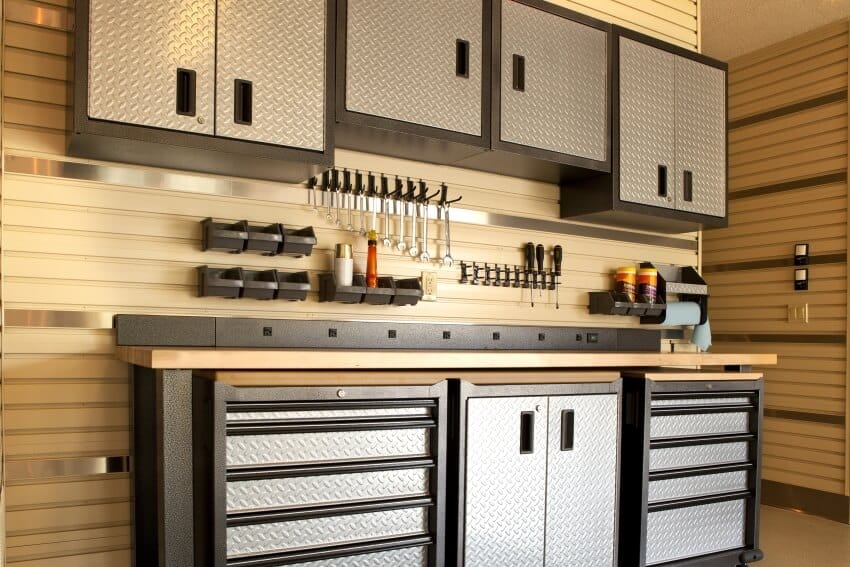 Garage workspace with cabinets, countertop, and tools and accessories on wall