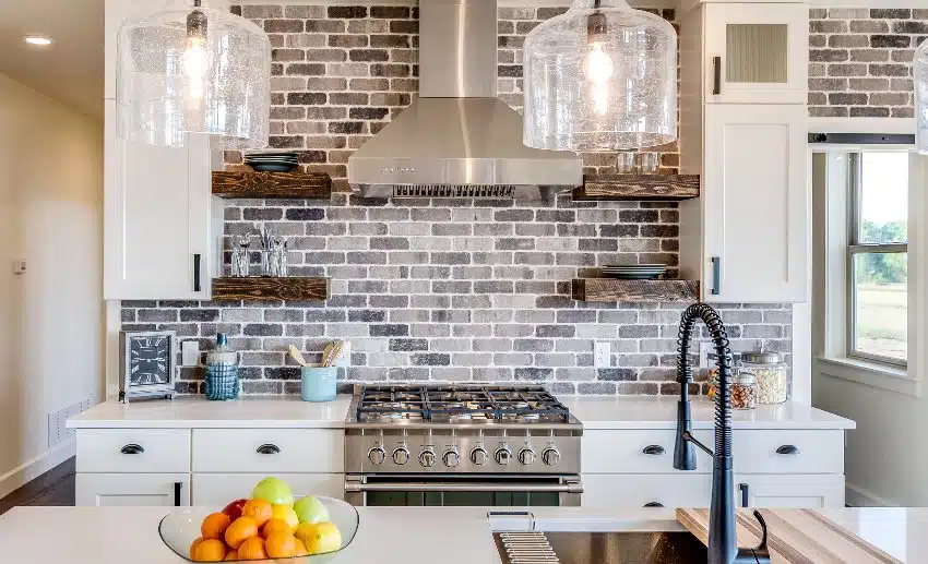 Gorgeous kitchen with vent hood, slate subway tile backsplash and island with sink