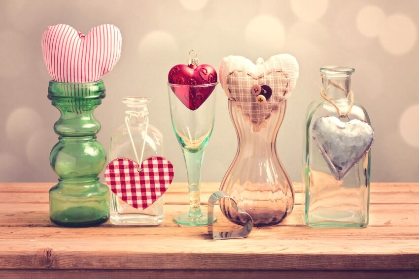Heart shapes valentines day decors in different vases on a wooden table