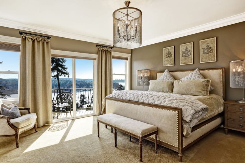 Home interior with bedroom set, bedding, pillows, chair, nightstand, chandelier, curtains, and windows