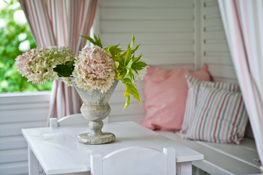 Pink cushions and curtains with floral vase 