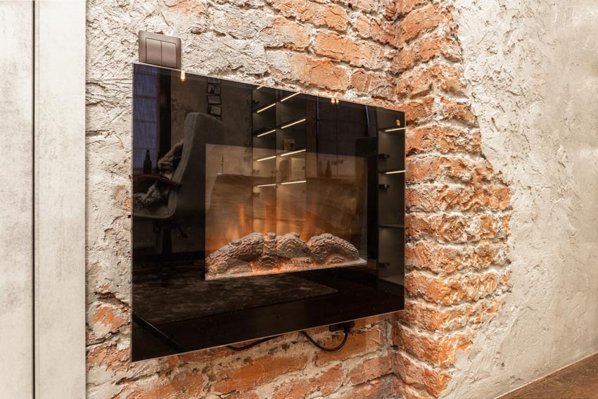 Home interior with small wall mount electric fireplace and brick wall