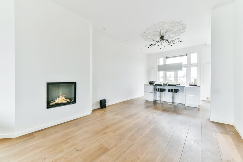 Home with white walls, bar counter, bar stools, wood floors and chandelier