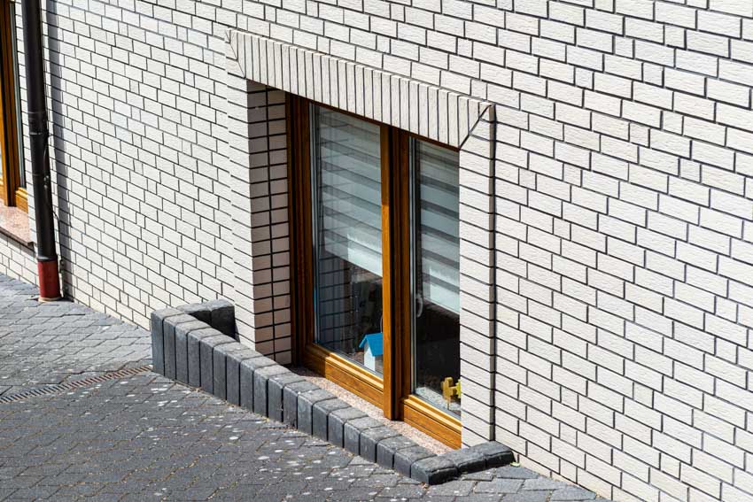 House exterior with wall cladding and basement type of window