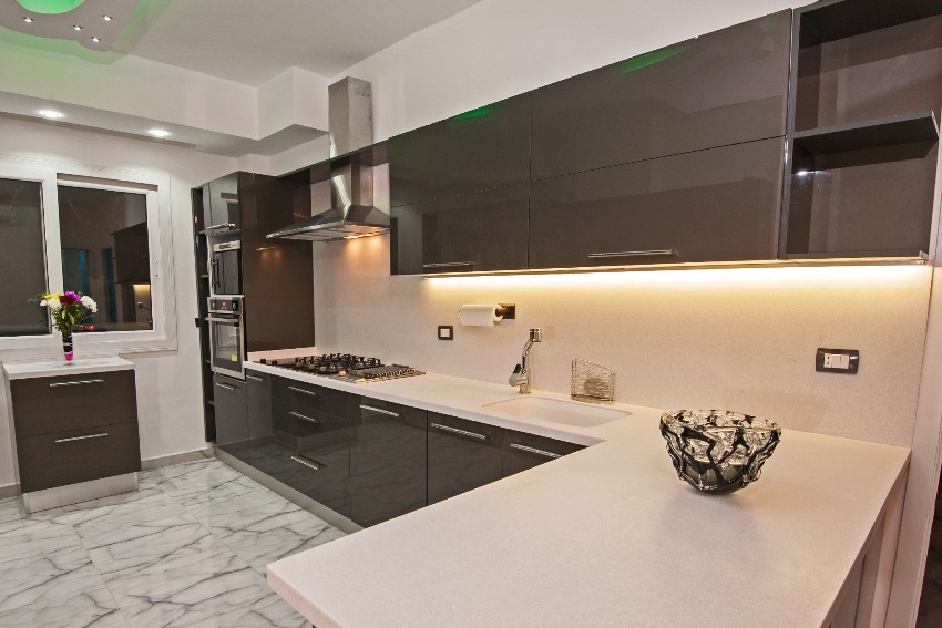 Interior design of a kitchen with modern pvc kitchen cabinets, marble floor tiles and appliances 