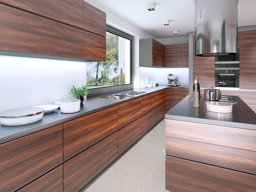 Kitchen with countertop, island, range hood, wood veneer cabinets, and window