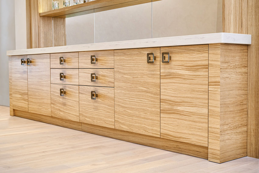 Kitchen with countertop, wood veneer cabinets, wooden flooring, and cabinet hardware