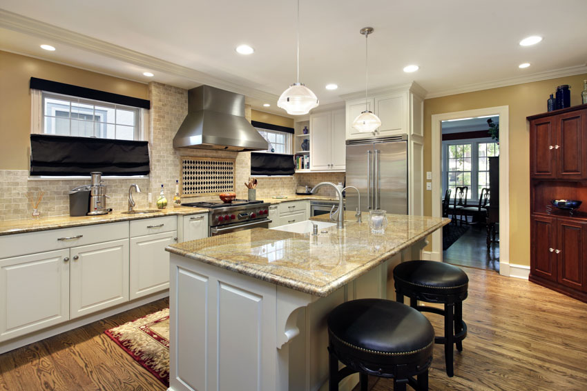 Ceiling with recessed lighting, black stools, and red carpet