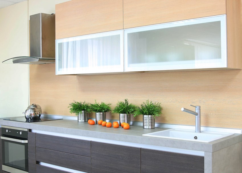 Wooden cabinets with frosted fronts, handleless under sink cabinets and oven