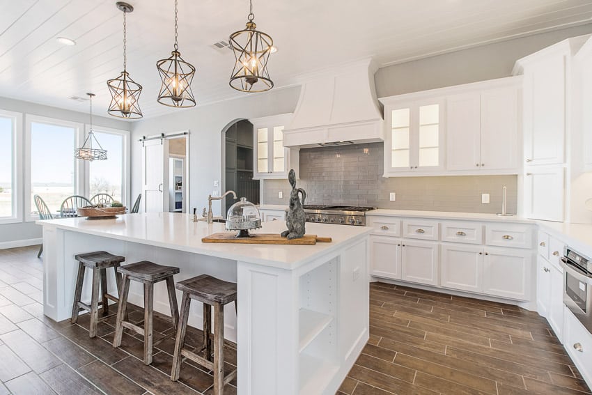 Kitchen with backsplash, island, countertops, cabinets, and windows