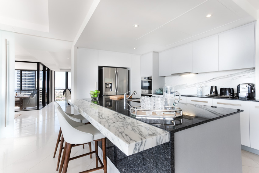 Kitchen with high chairs, white cabinets, backsplash, refrigerator, ceiling lights, and marble countertop