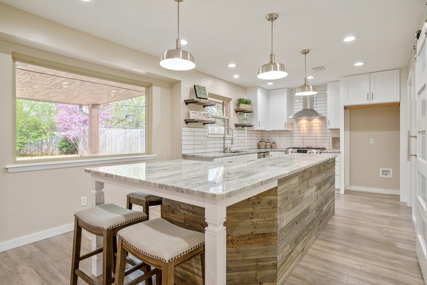 Soft neutral palette with white marble countertop, shelves and picture window