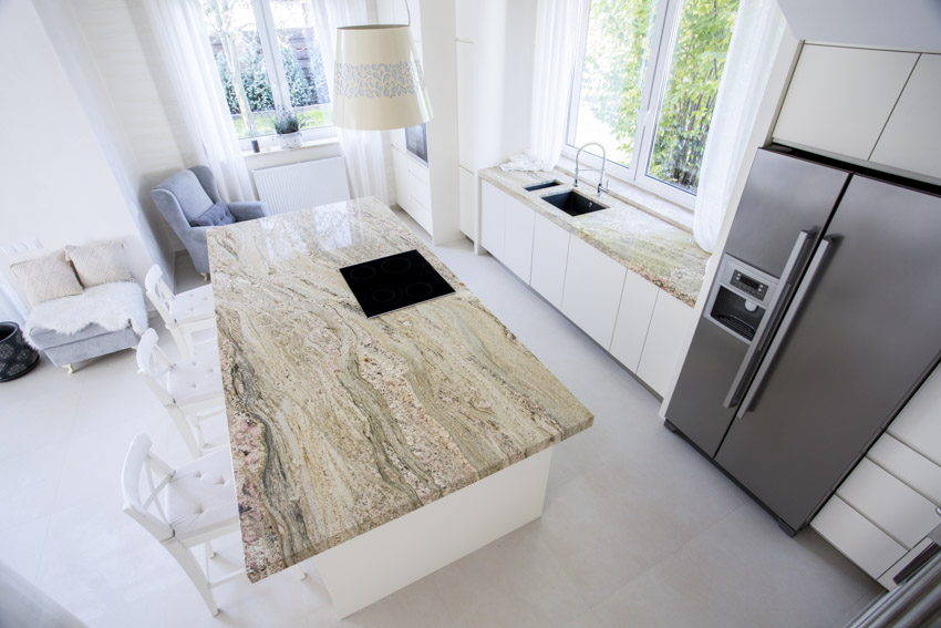 Kitchen with island, refrigerator, granite counter, sink and windows
