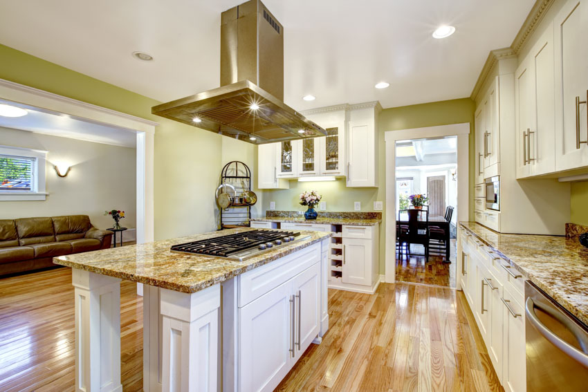 White island, built-in hob, brass hood and white classic cabinets