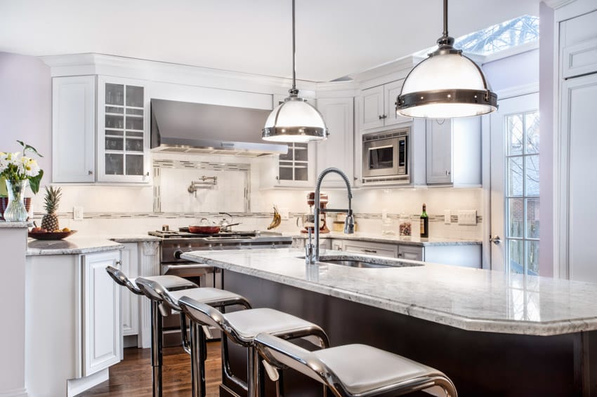 Kitchen with listello tile backsplash, countertop, high chairs, pendant lights, cabinets, and window