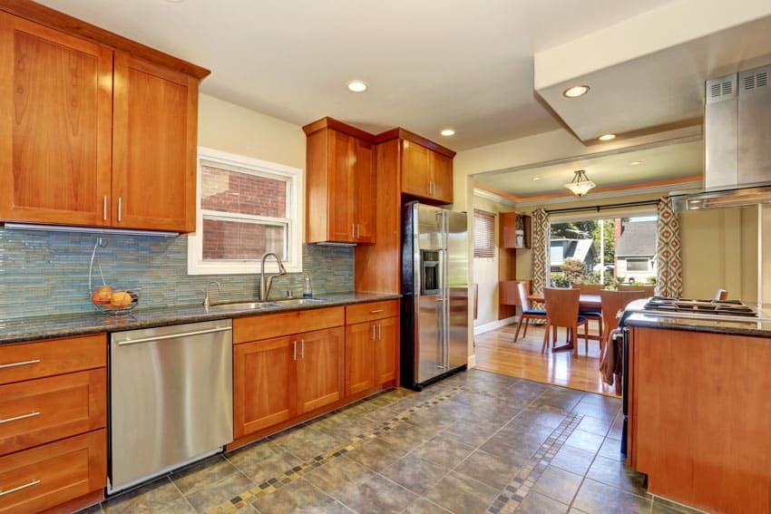 Kitchen with backsplash, window, and cabinets