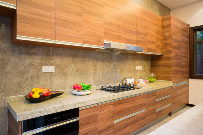 Kitchen with wood veneer cabinets, backsplash, countertop, and cabinet hardware