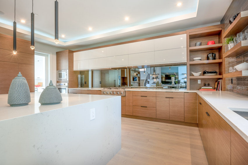 Kitchen with wooden flooring, modern pendant lights, shelves, wood veneer cabinets, and countertop