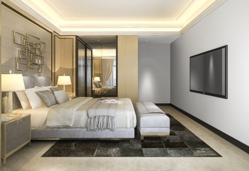 Light gray bedroom with golden wall decor and black carpet