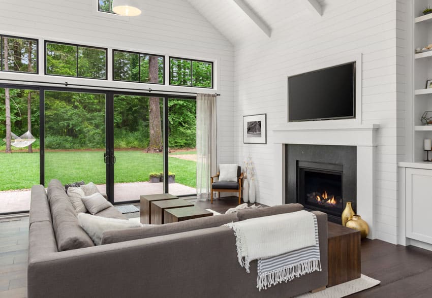 Room with fireplace, television, beadboard wall, couch, pillows, and windows