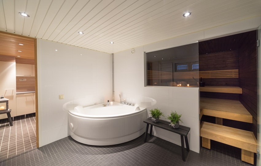 Bathroom with beadboard ceiling, jacuzzi, and small side table