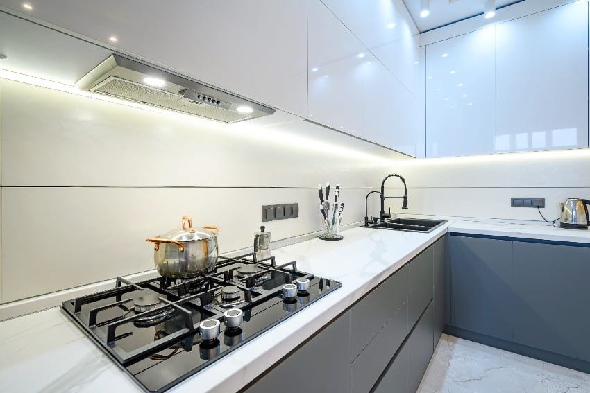 Luxury white and gray modern kitchen interior with under cabinet valance lighting