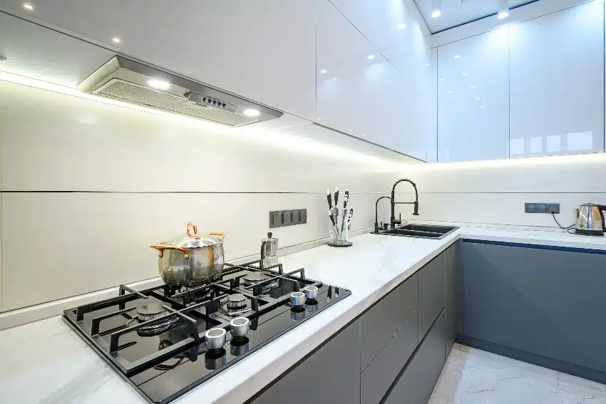 Luxury white and gray modern kitchen with under cabinet lighting