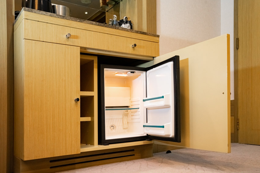 Mini refrigerator inside a wooden cabinet
