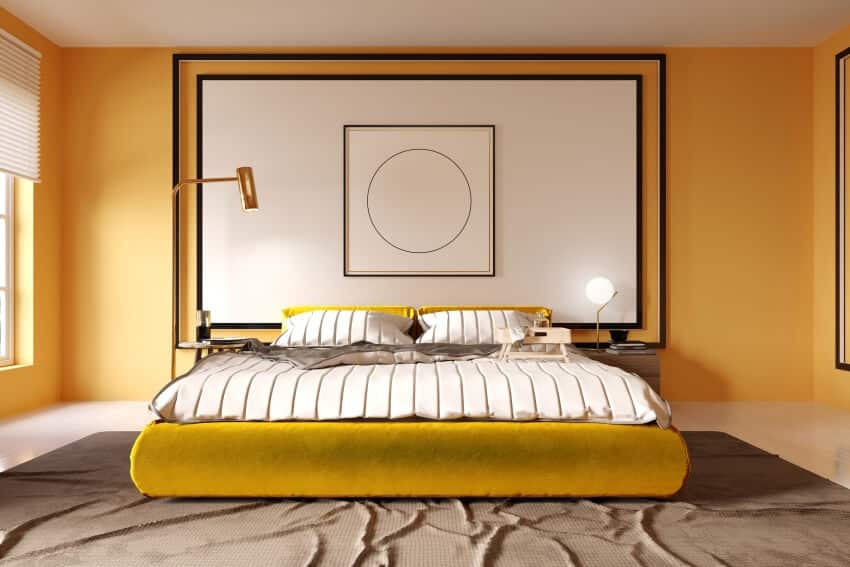 Bedroom with mustard colored bed, carpet, wall artwork