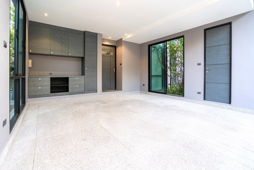 Modern garage with sliding door to a garden, gray painted walls, and concrete floor