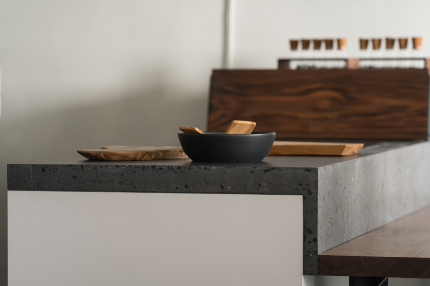 Modern kitchen with cement recycled glass countertop, bowl, and wooden cutting board