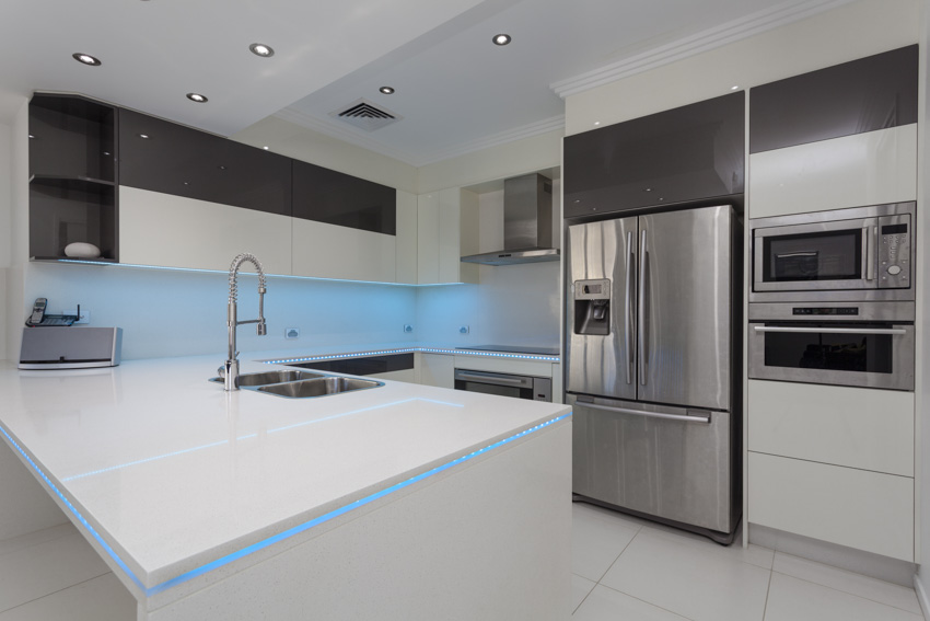 Modern kitchen with island, countertops, cabinets, refrigerator, and oven