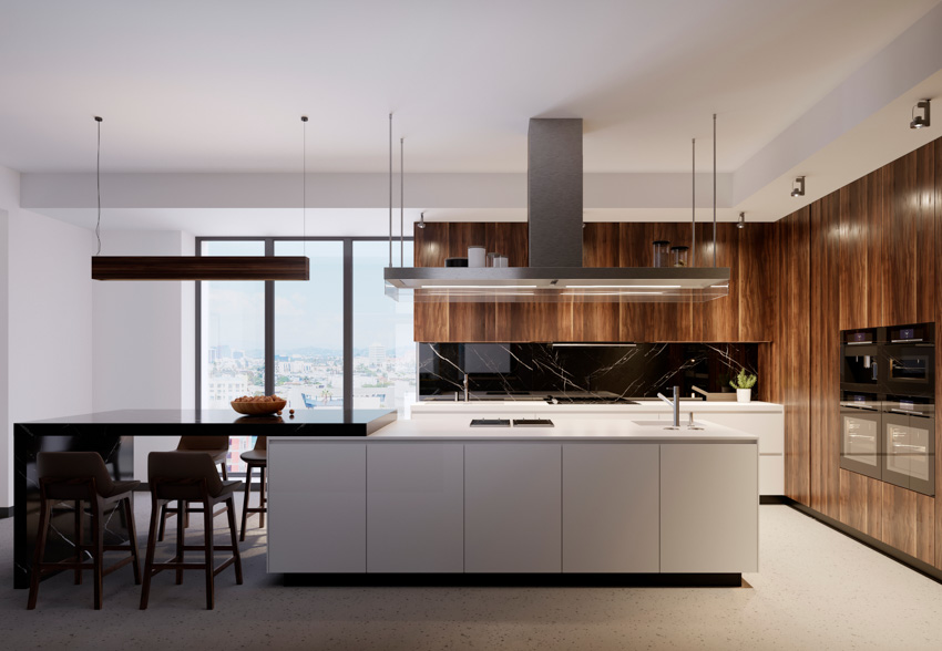 Modern kitchen with island, range hood, wood veneer, cabinets, table, chairs, and window