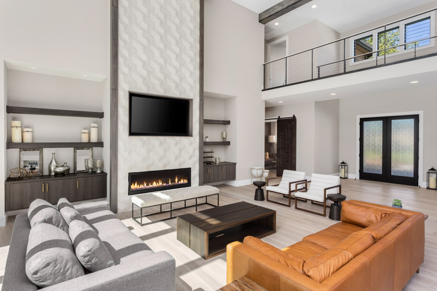 Modern living room with electric fireplace, wavy tile mantel design, couch, coffee table, shelves, and television