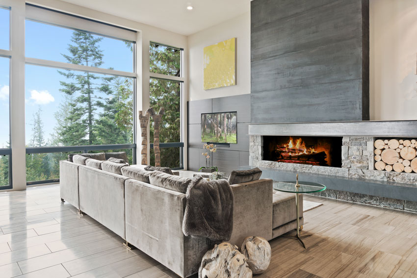 Living room with velvet fabric sofa, slate walls and floor to ceiling windows