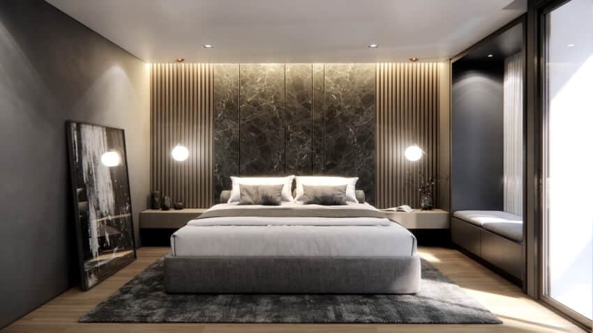 Modern luxury bedroom with dark gray walls, seating bench, and a marble and panel accent walls