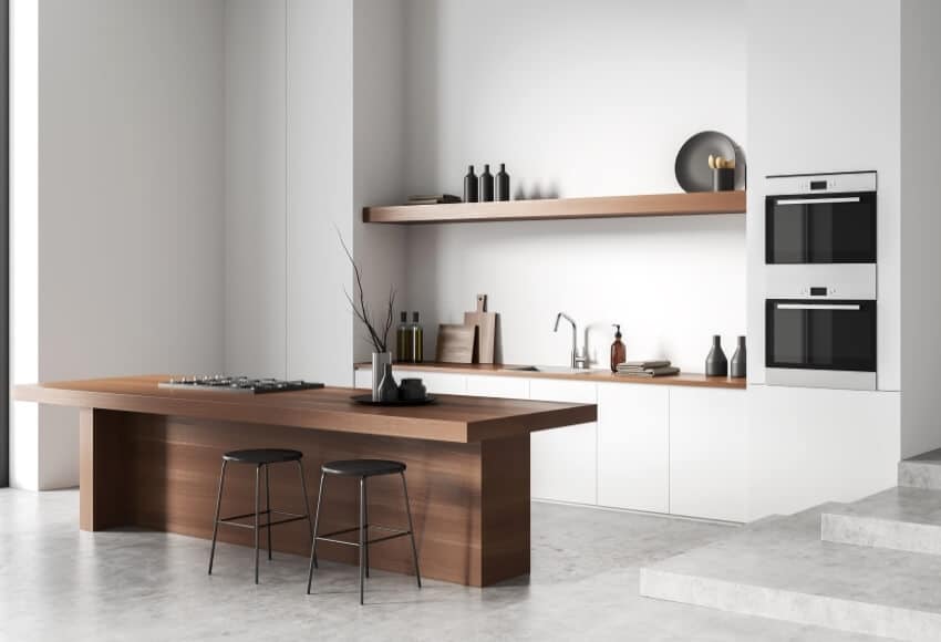 Modern white kitchen interior with solid wood island, light concrete floor, and shelf with art decoration