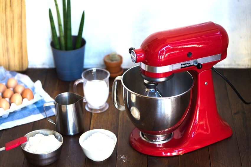 Red standing mixer and baking ingredients on a table