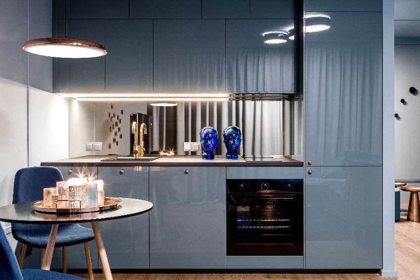 Small and elegant kitchen interior with blue pvc kitchen cabinet design and dining area