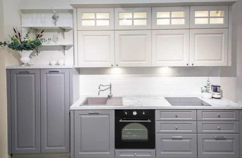 Traditional kitchen with Carrara marble countertop, backsplash, sink, faucet, and cabinets