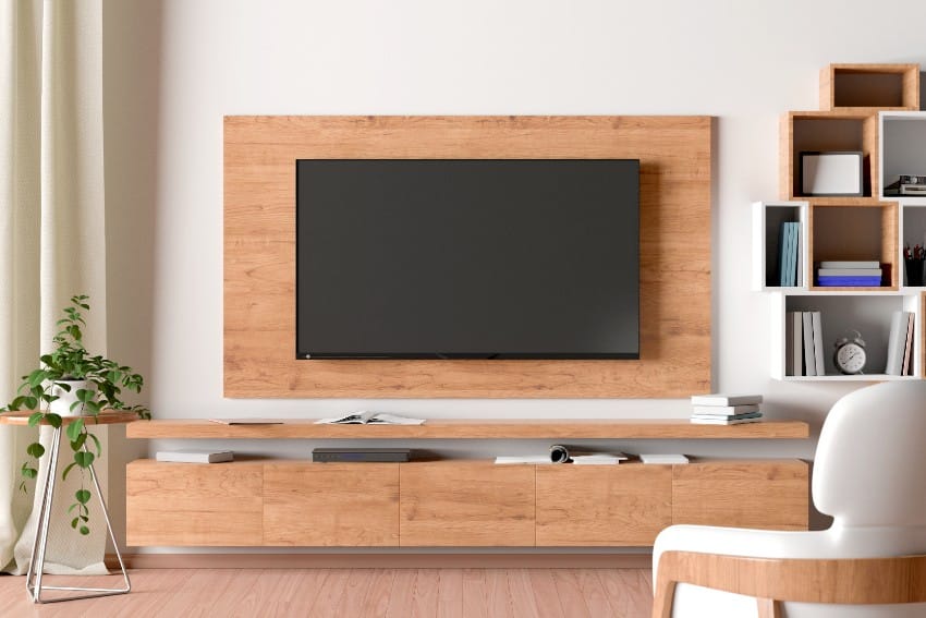 Smart tv mounted hang on okoume panel wall in living room with shelf and decor in modern interior